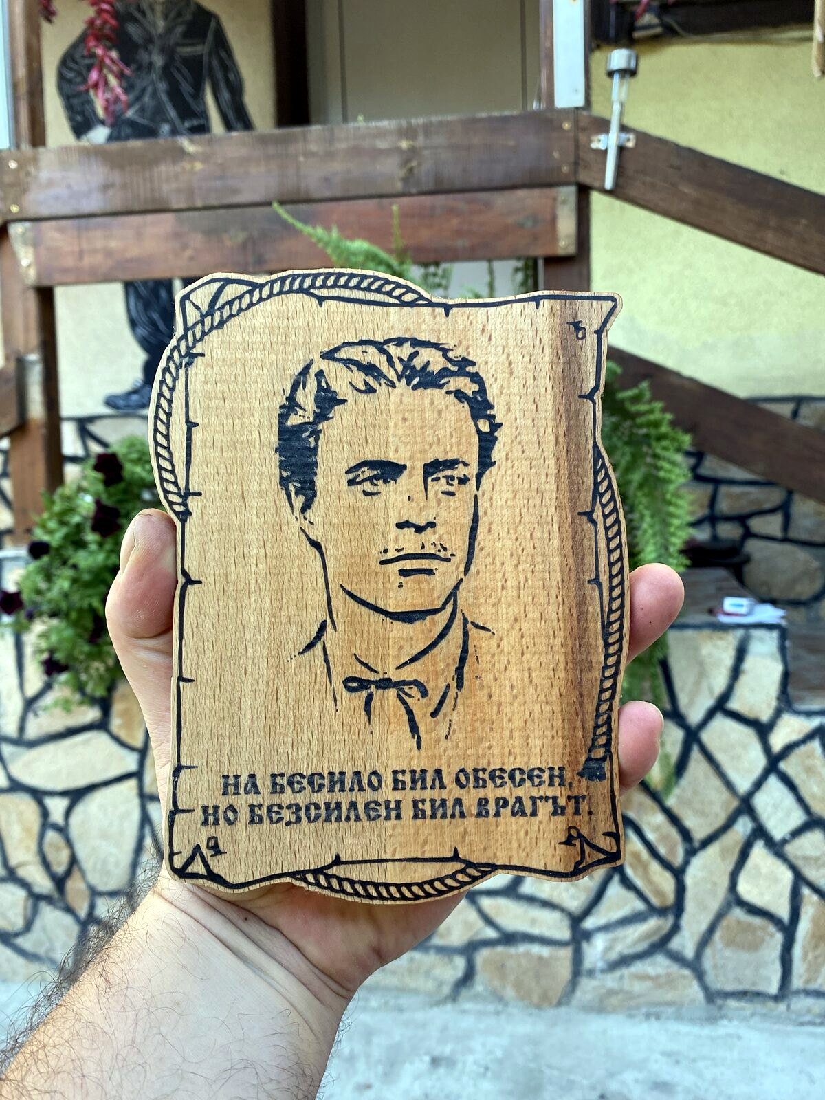Someone holding a newly carved Levski wooden plaque