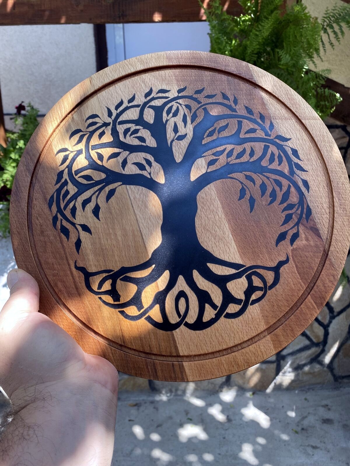 Holding the finished Tree of Life wood carving outdoors