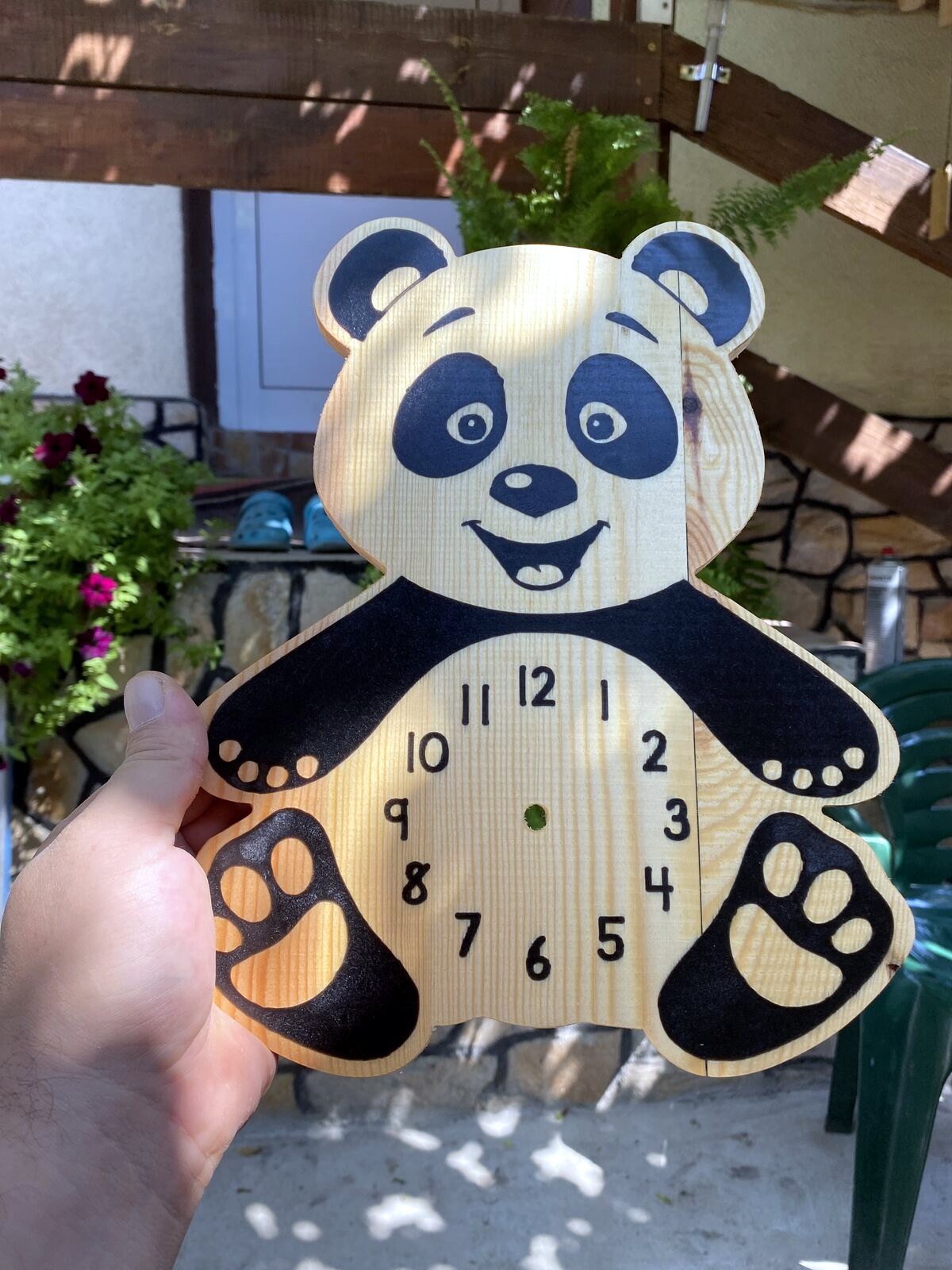 Finished wooden panda wall clock hanging in workspace